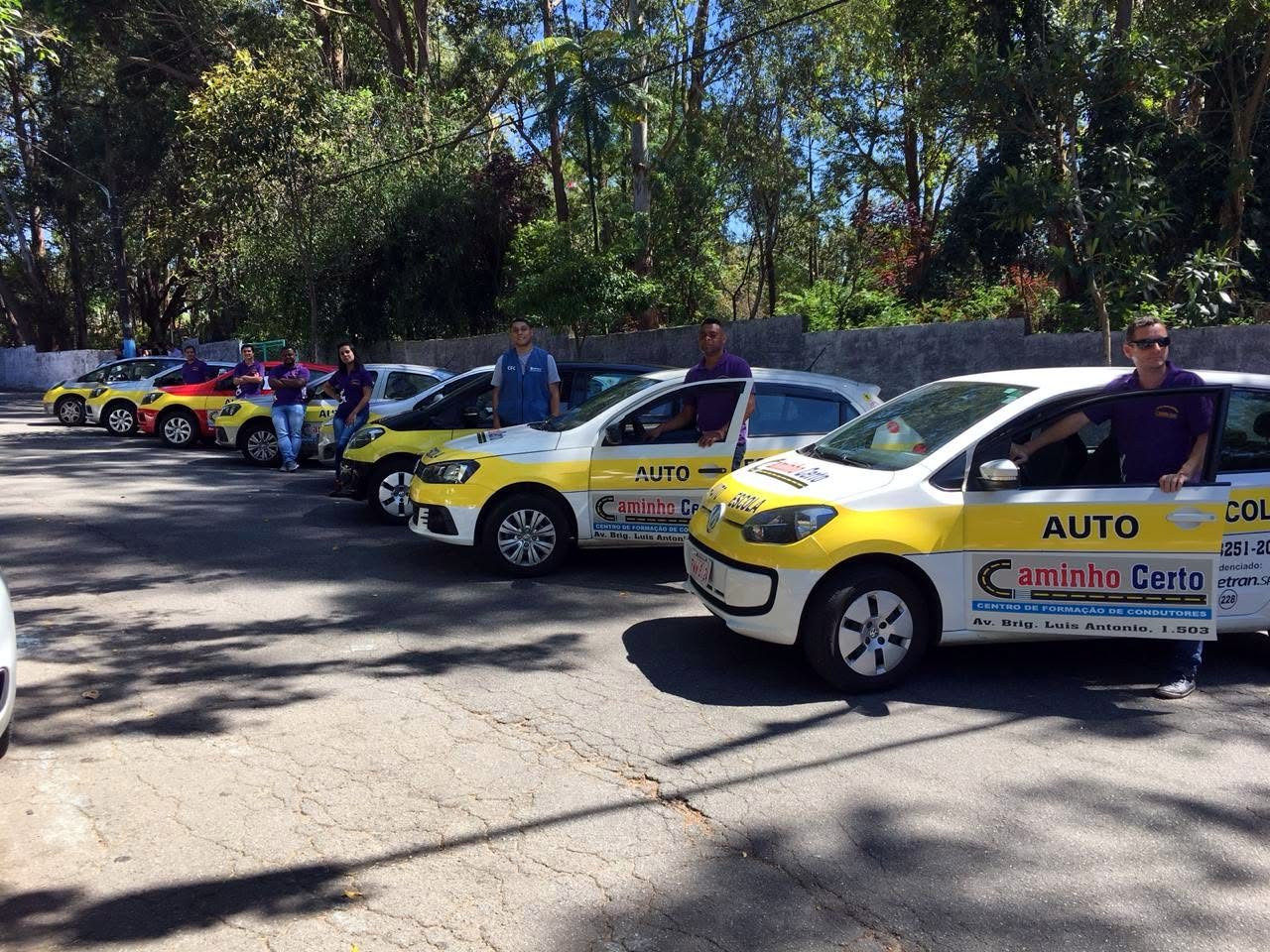 Instrutores da Caminho Certo ao lado da frota de carros adesivados